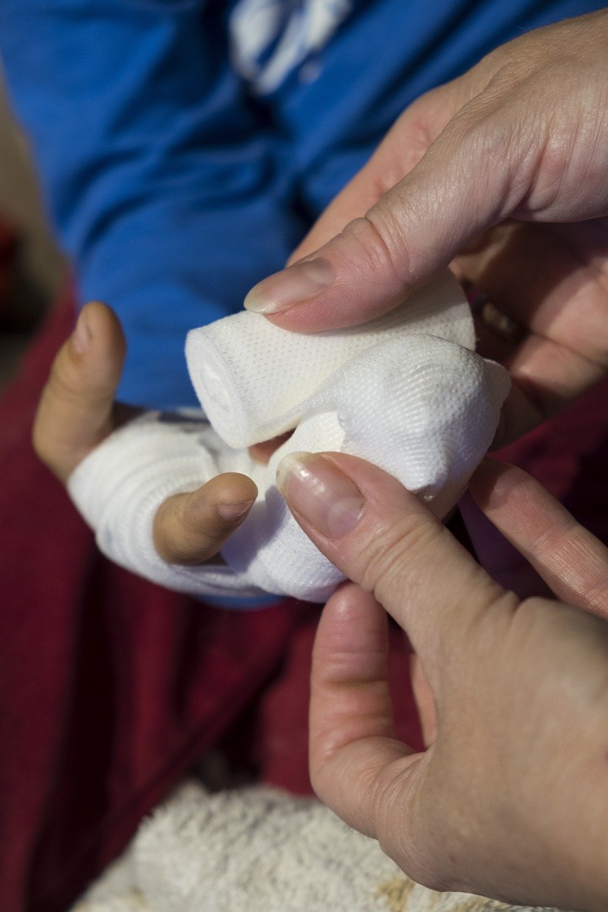 Image en noir et blanc montrant des mains qui s'occupent d'un bandage. Le texte superposé indique : "Formez-vous aujourd'hui, agissez demain : devenez un héros !" Le message souligne l'importance de la formation au secourisme et incite les gens à devenir acteurs de la sécurité.